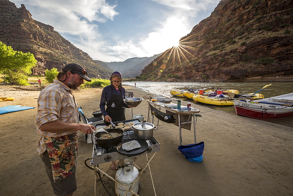 Two rafting guides cooking a meal at camp while on a Green river rafting trip, Desolation/Gray Canyon section, Utah, USA