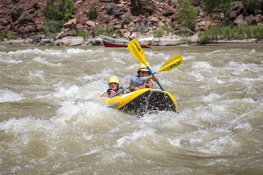 A man and woman paddling an?inflatable?kayak through rapids on a Green river rafting trip, ?Desolation/Gray?Canyon section, Utah, USA