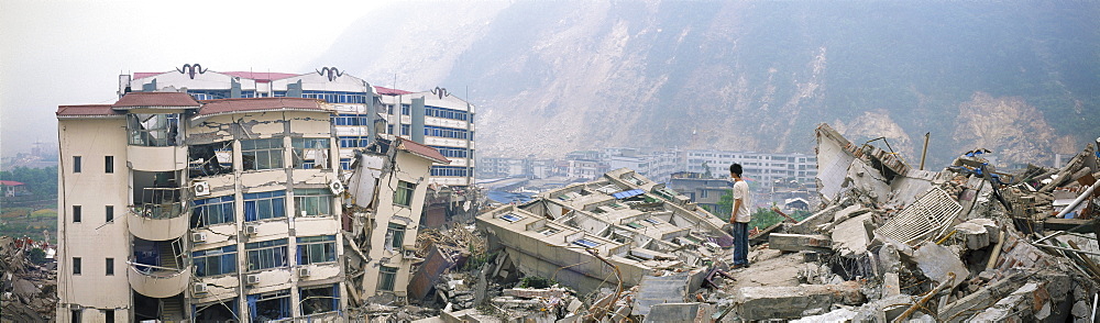 A survivor stands amid ruins in May 17 in Beichuan, China. The death toll in China's worst earthquake in 30 years could top 80, 000 according to the government.