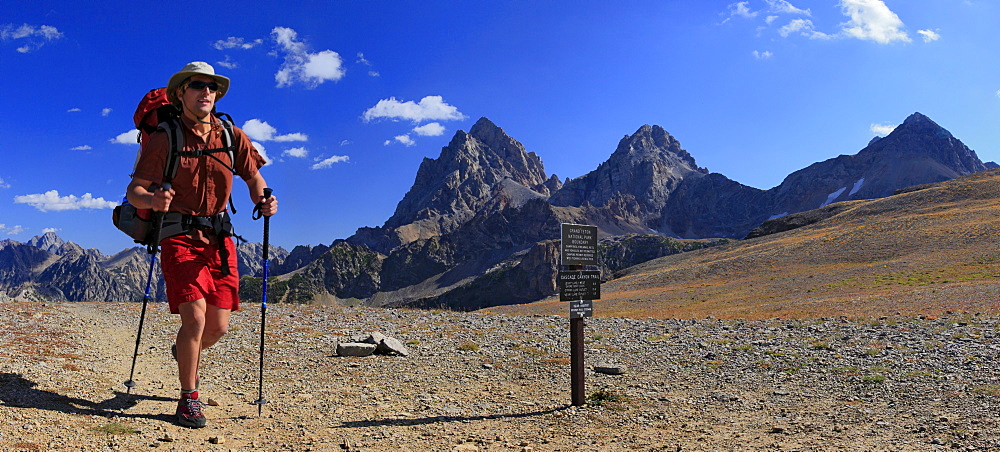 Solo hiker in Grand Teton National Park passing trail sign