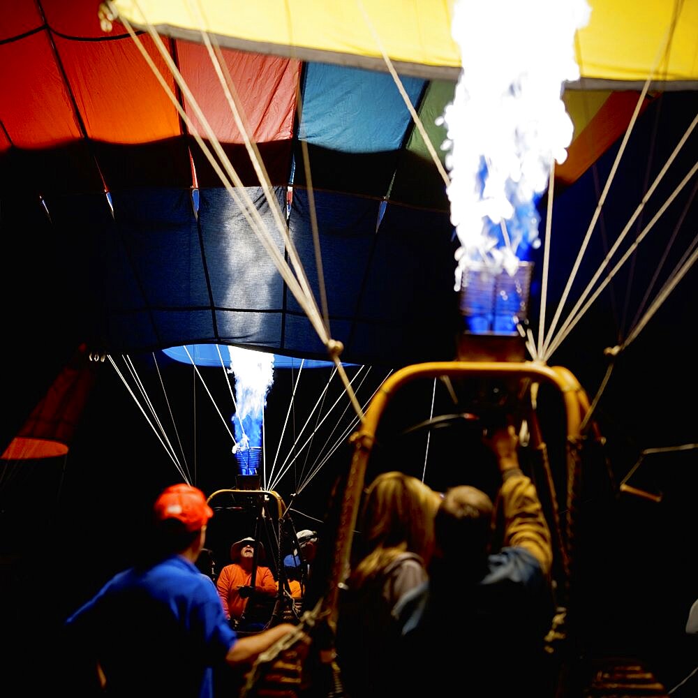 Gas burners inflating two balloons in the morning darkness at the Sonoma County Hot Air Balloon Classic.