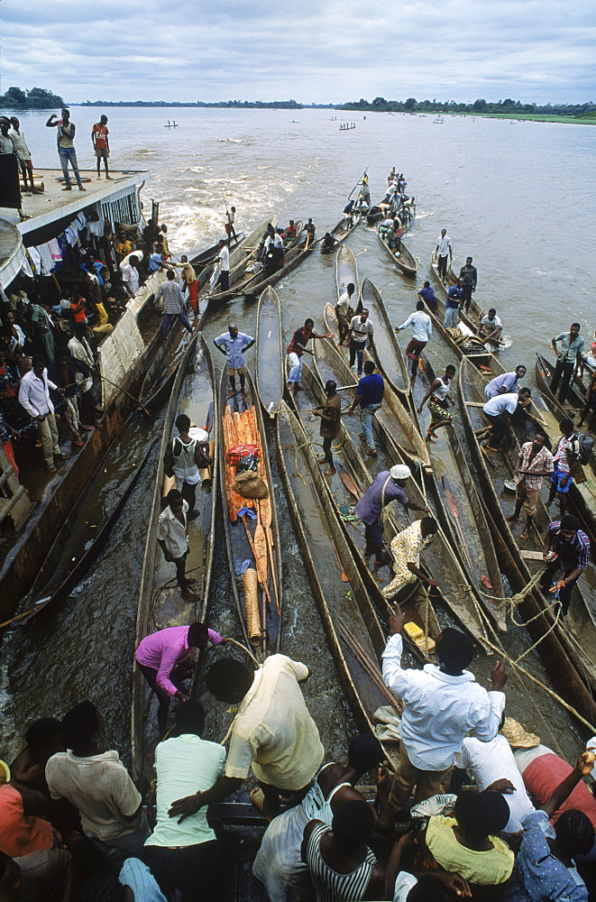 Some of the hundreds of dugout canoes or pirogues that are paddled out to tie onto the boat and barges that steam up the congo River. People who live along the river bring bush meat, fish, and produce to trade with the merchants who travel on the boat.