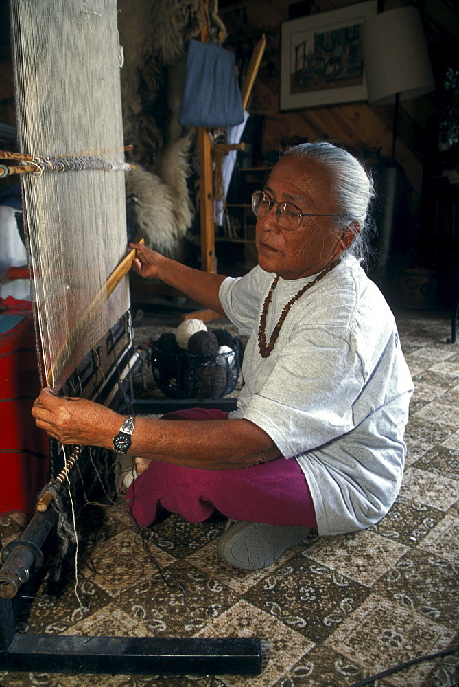 A Navajo weaver weaves a rug in her home near Shiprock, New Mexico on the Navajo Indian Reservation.