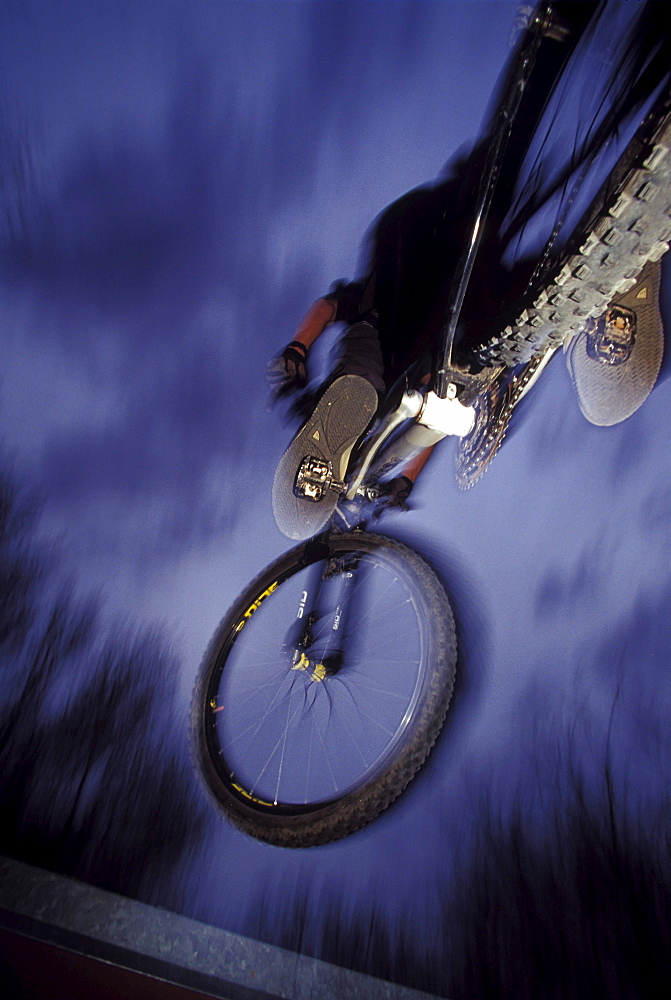 Man jumps mountain bike as seen from below, Utah