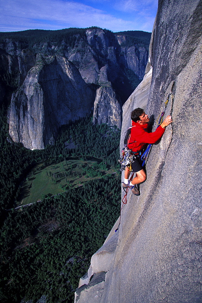 Chris McNamara uses a sky hook to move higher while rock climbing Mescalito on El Capitan in Yosemite National Park, California. By the time McNamara was 18 years old he had rock climbed the 3000 foot high El Capitan more than 50 times. El Capitan is considered a big wall and usually requires aid climbing.