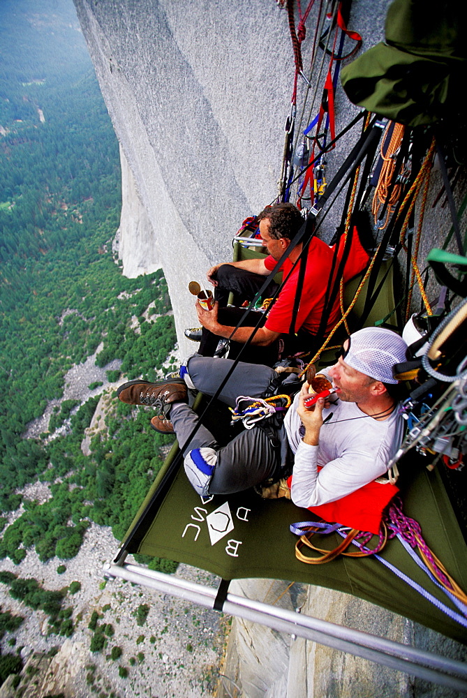 Bob Porter and Martin Avidan rest and eat dinner on a portaledge while rock climbing, aid climbing, big wall climbing up the Zodiac 5.13+ on El Capitan in Yosemite National Park, California. The team spent three days and two nights on the big wall.