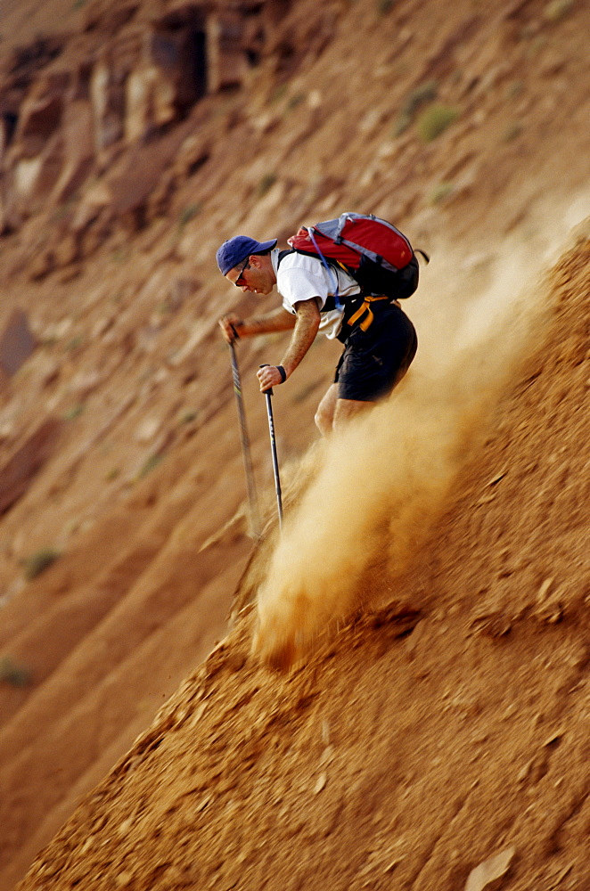 Shawn Hanka hiking down the sand dunes in Moab, Utah.