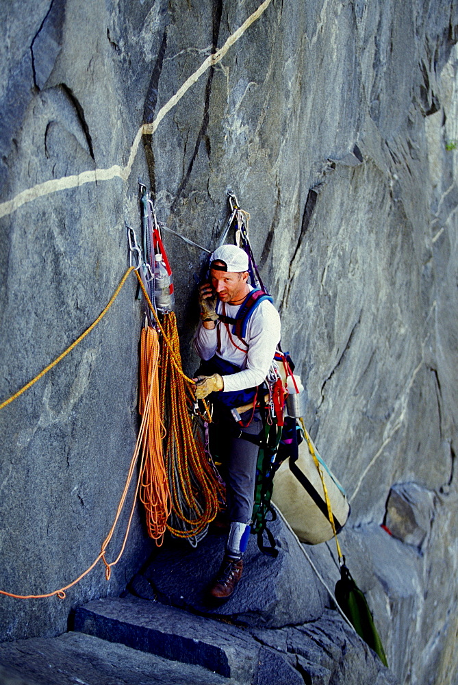 Martin Avidan takes a break to phone home from a ledge on Zodiac, a 16 pitch 5.11 A3+ route on El Capitan in Yosemite National Park, California.