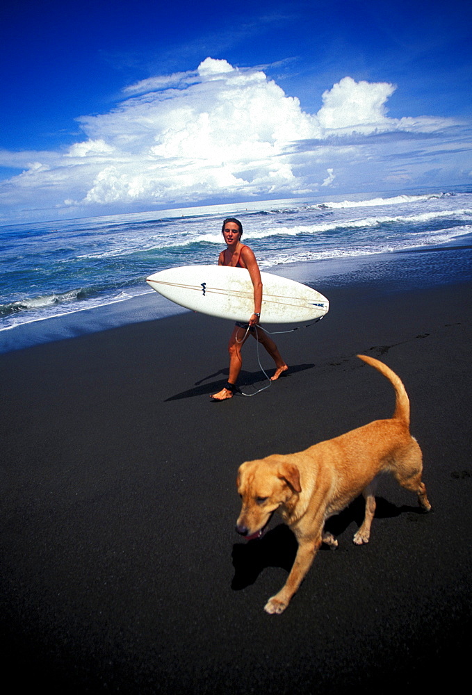 Pope Baskerville and her dog enjoy a leisurely day of surfing at Playa Hermosa, Costa Rica. Playa Hermosa is known for its powerful beachbreak and has one of the most consistent wave breaks in Costa Rica.