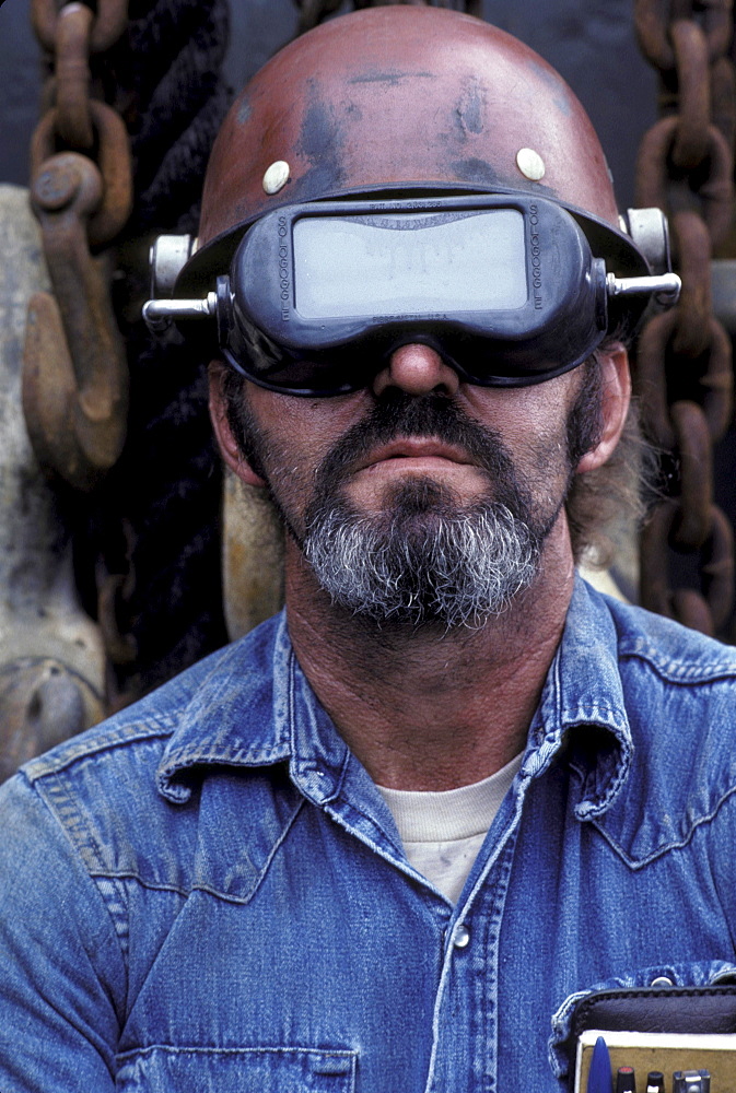 Portrait of a welder wearing a protective helmet.