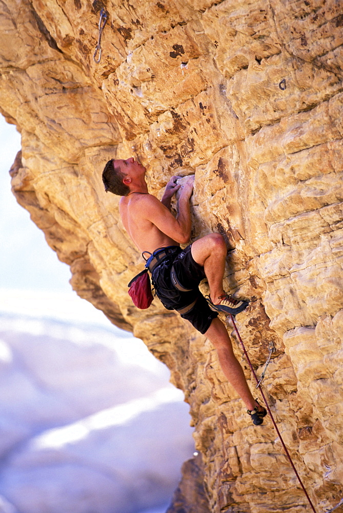 Male rock climber Tommy Caldwell climbing an overhanging route at the Red Rock Conservation Area in Nevada. Tommy is one of the greatest big wall climbers in the world.