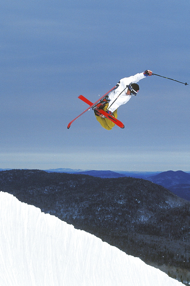 Young male skier (Garrett Brittain) performs a "mute grab" in the halfpipe at Mont Tremblant, Quebec, Canada.