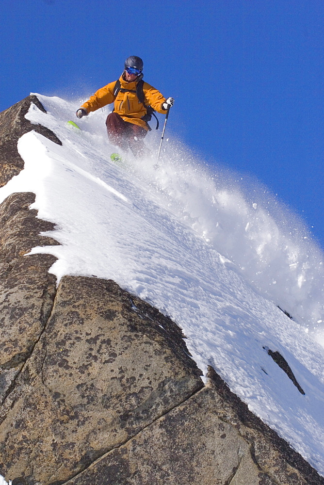 A man skiing powder snow on a rock on Donner Summit in California.