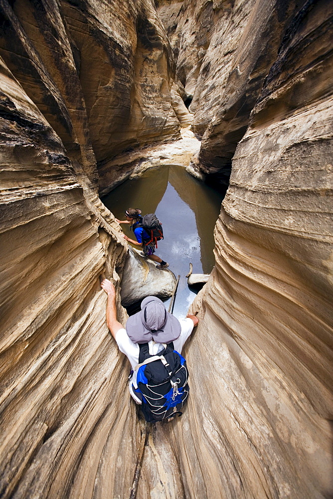 Jeff Crystol foreground and Josh Williams in backround descending Miners Hollow or Knotted Rope Canyon, San Rafael Swell, Utah.