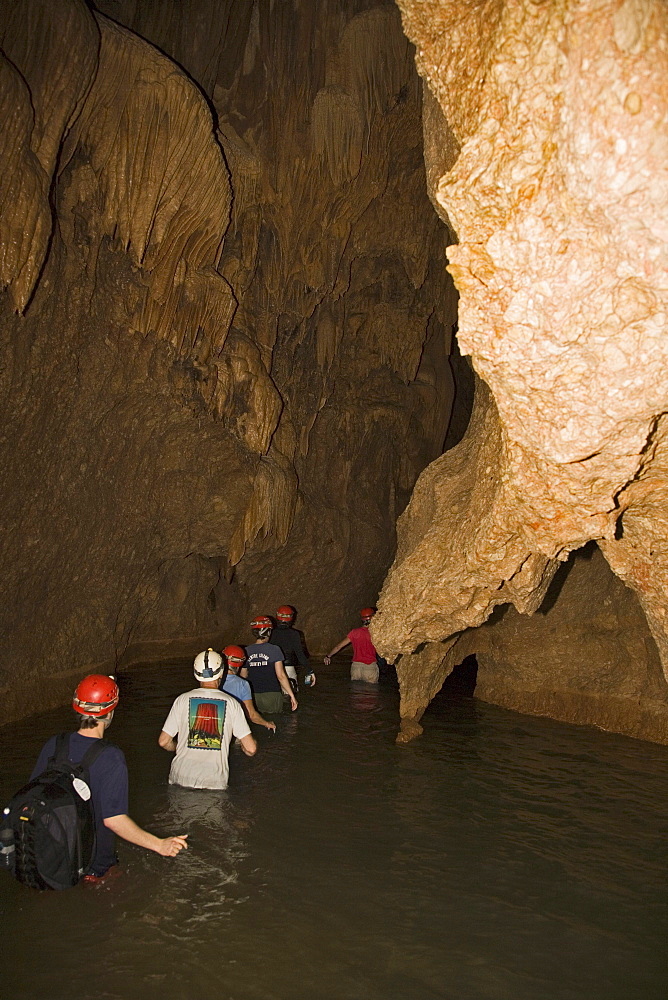 Group of adventure tourists spelunking in Actun Tunichil Muknal cave, central Belize.