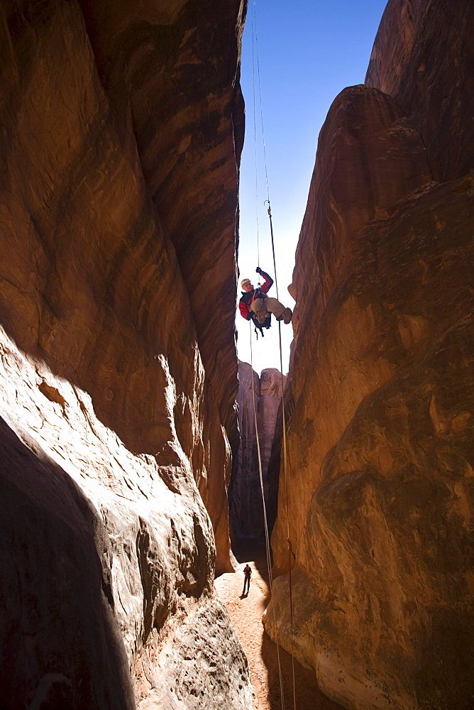 A man rappelling in Arches National Park, Moab, Utah.