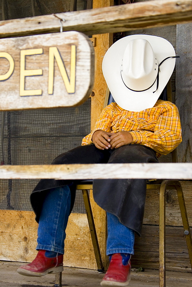 Young cow boy on porch, Wyoming