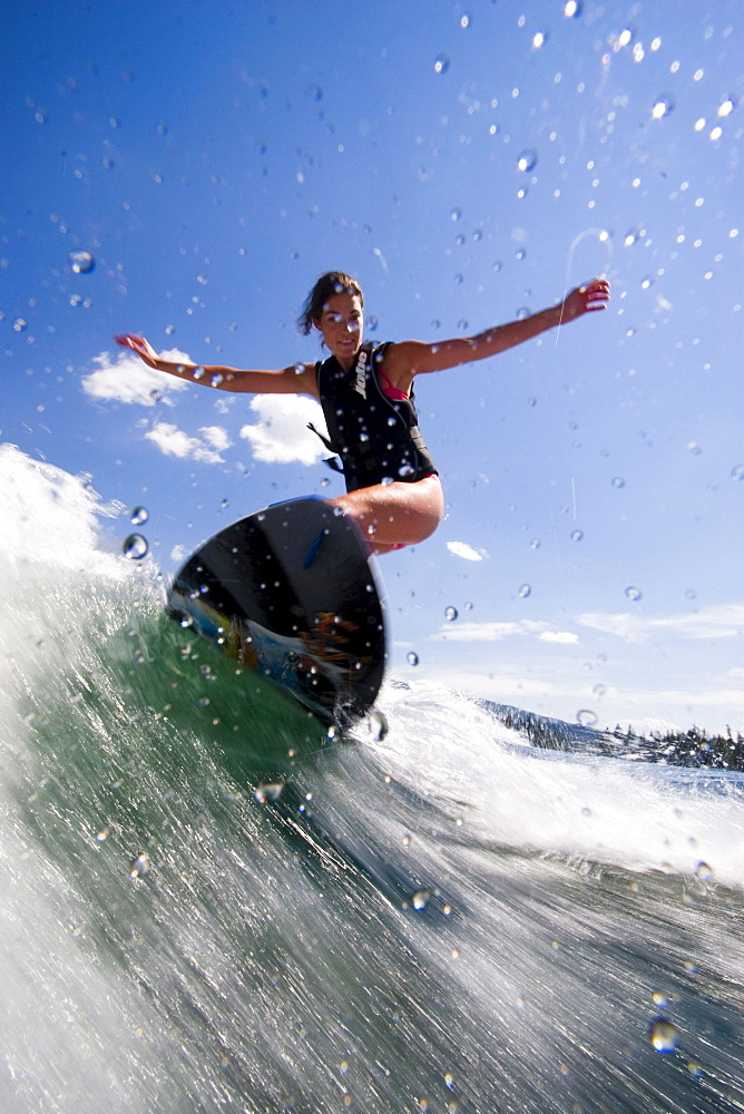 Woman wake boarding on sunny day, Idaho