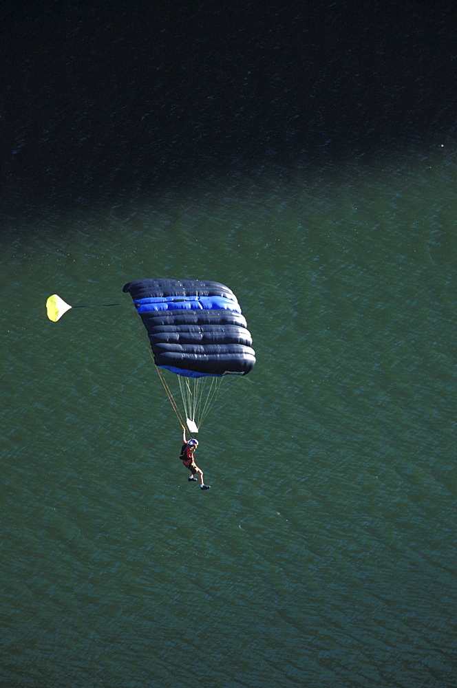 A BASE jumper glides down into a river after jumping off of a bridge in Twin Falls, Idaho.