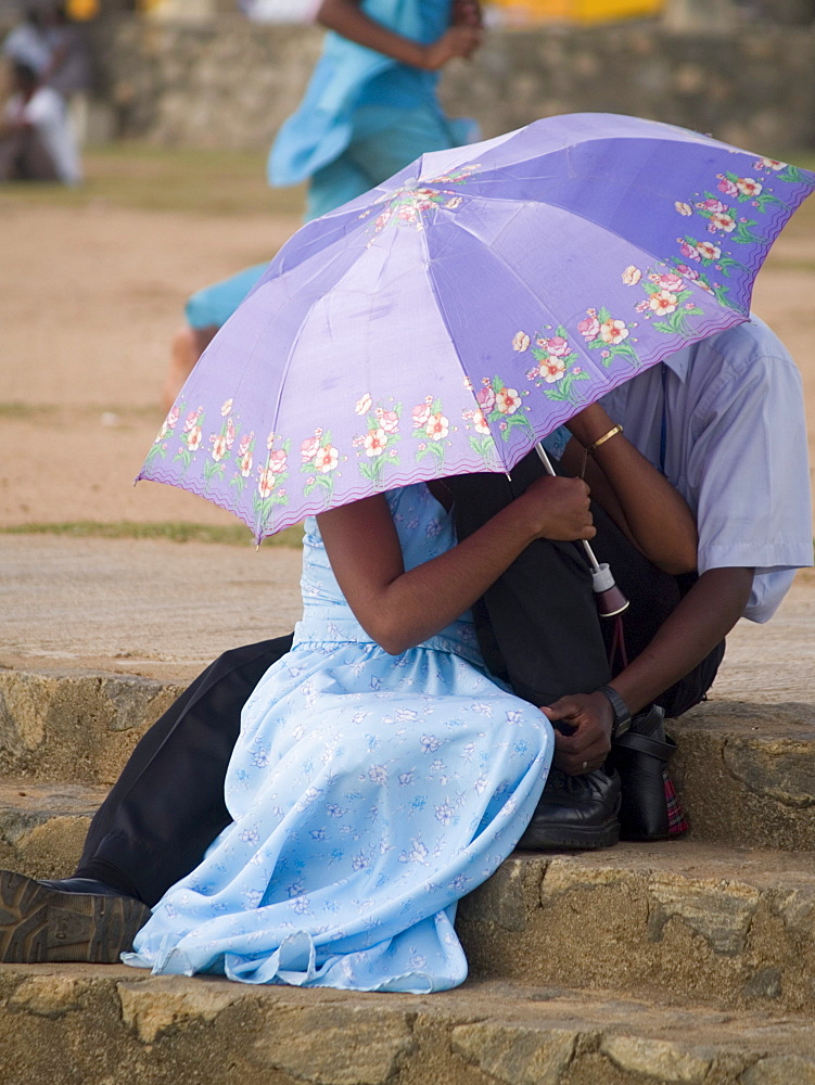 Young couples using umbrellas for privacy