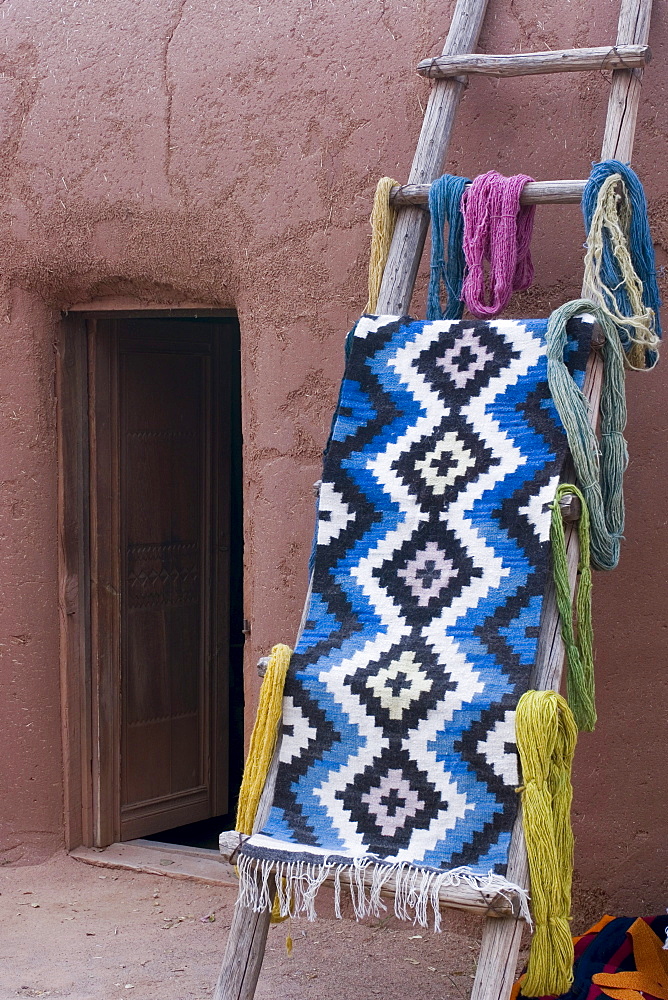 A woven mat drapped over a ladder in New Mexico.