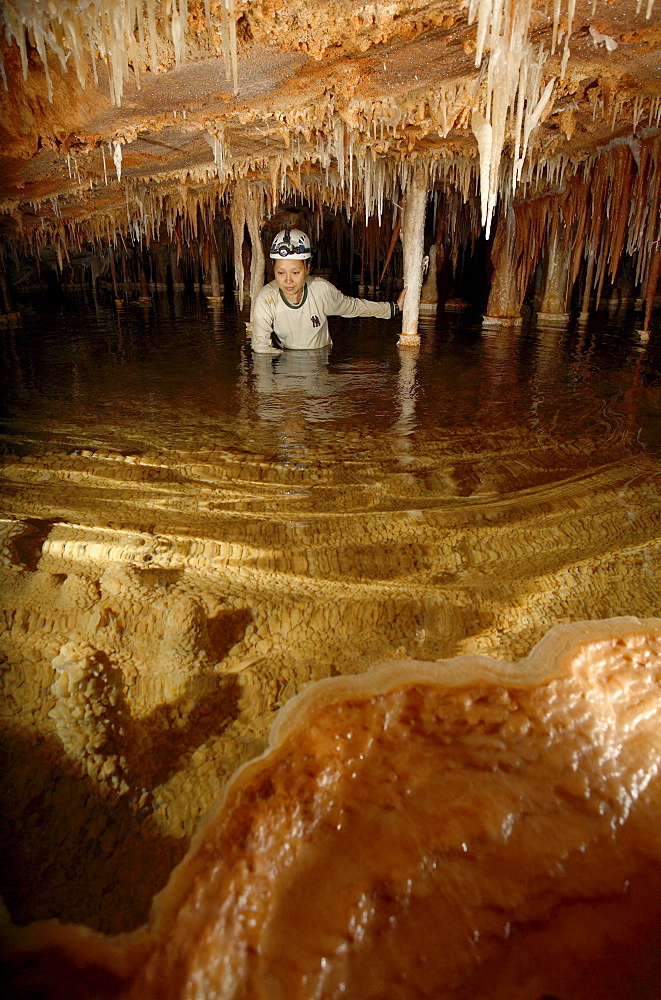 A female cave explorer wades through the terminal Gour Pool so very close to the surface at the most remote part of Whiterock (c