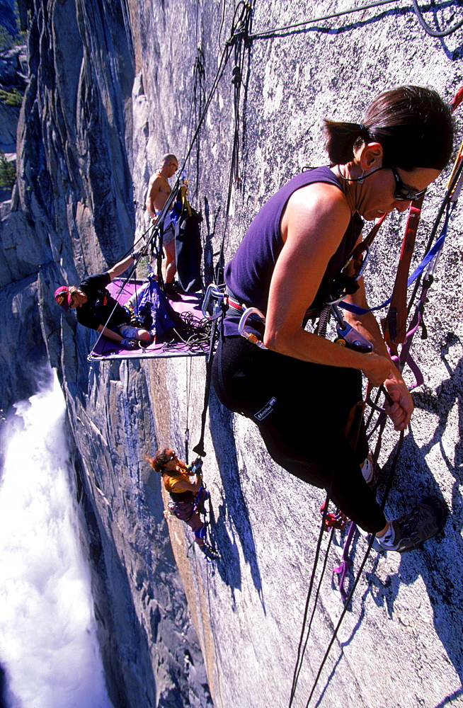 Preparing to dance, Kimm E. Ward checks her harness and climbing devices. Climbing skills and safety checks are integral for these performers of which many started as rock climbers before integrating dance into their vertical world.