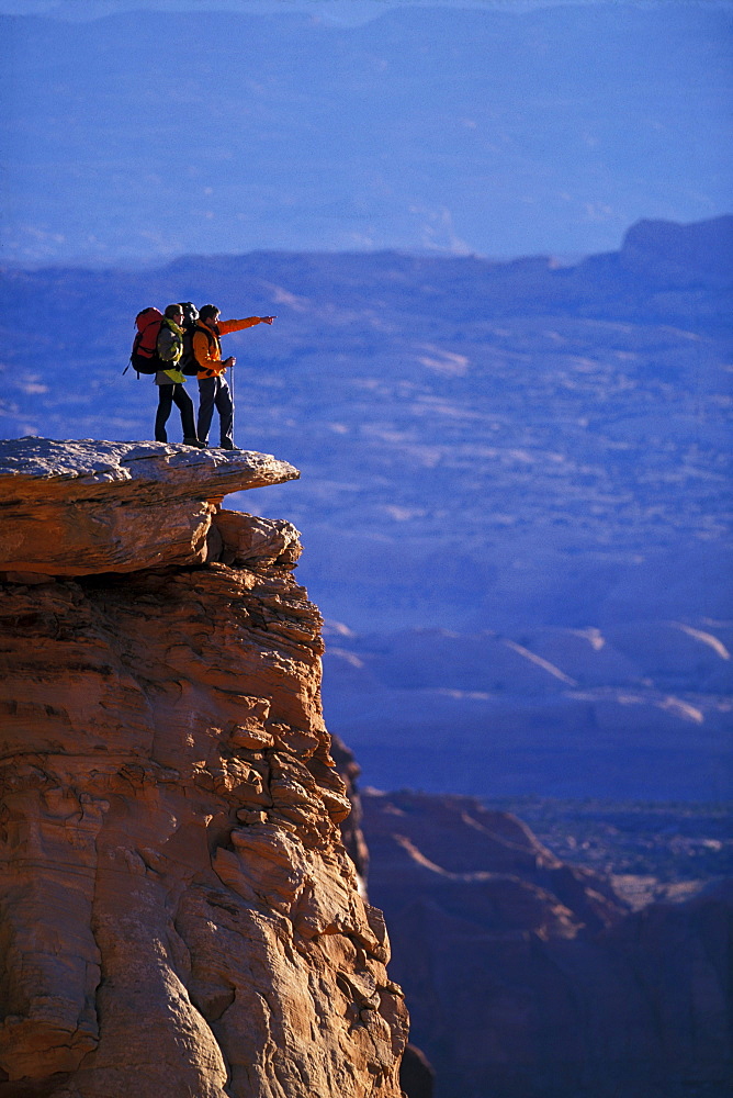 Couple checking out the view from an overlook while backpacking in Canyonlands national park.