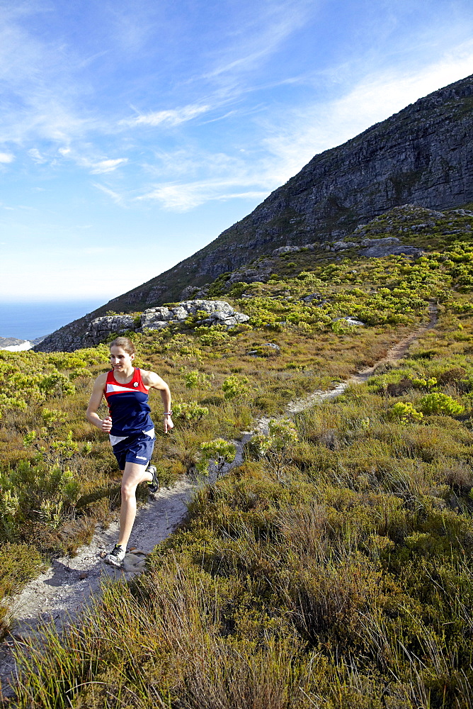 Susann Scheller running on a small trail near Silvermine in Table Mountain National Park. Cape Town, South Africa.