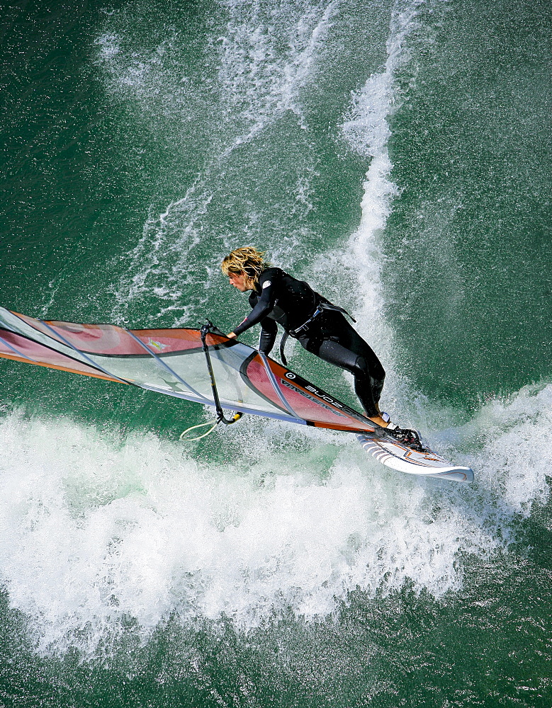 A windsurfer throws a move during a sweet summer session under the Maryhill Bridge.