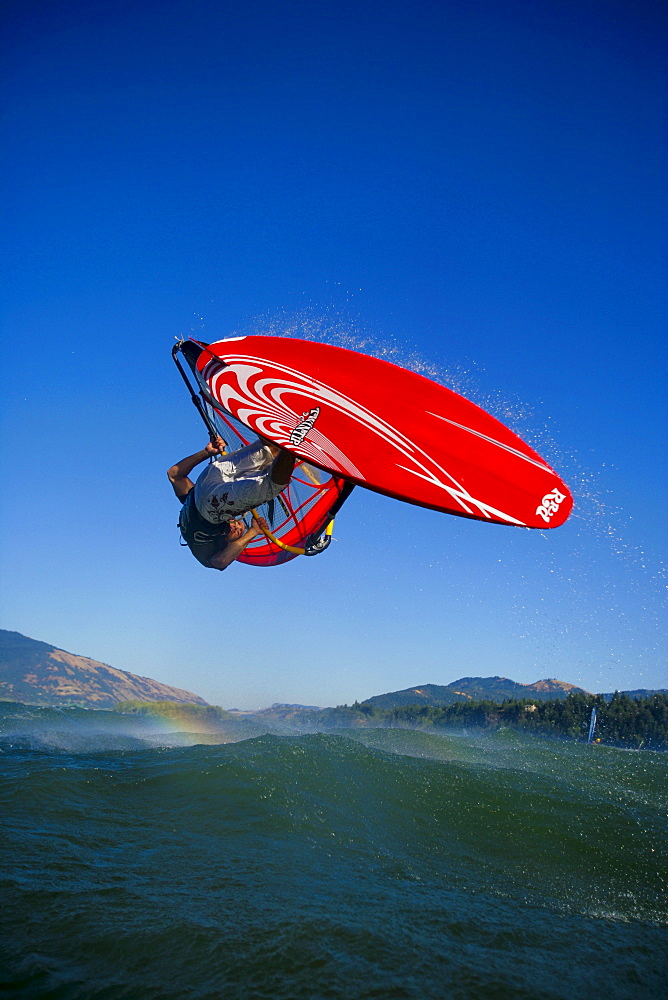 Windsurfer lofts a beautiful forward loop over the middle of the Columbia River Gorge.