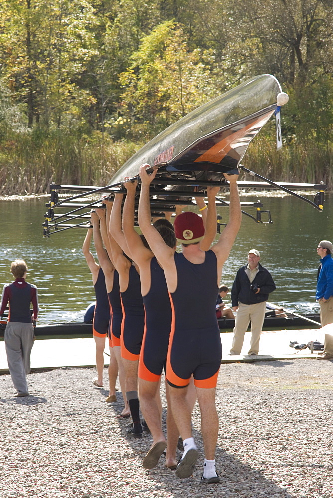 Members of the men's crew team at Hobart College carry their 8 man shell above their heads toward the water at the Hobart Crew Ragata, in Geneva, New York.