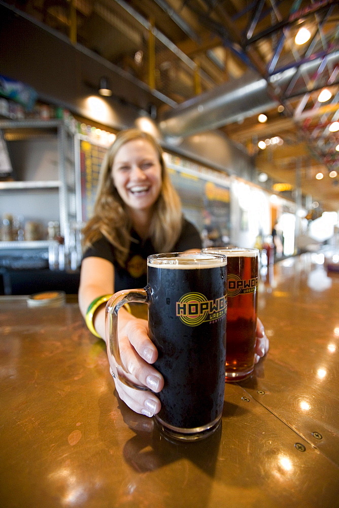 Woman serves beer in bar.