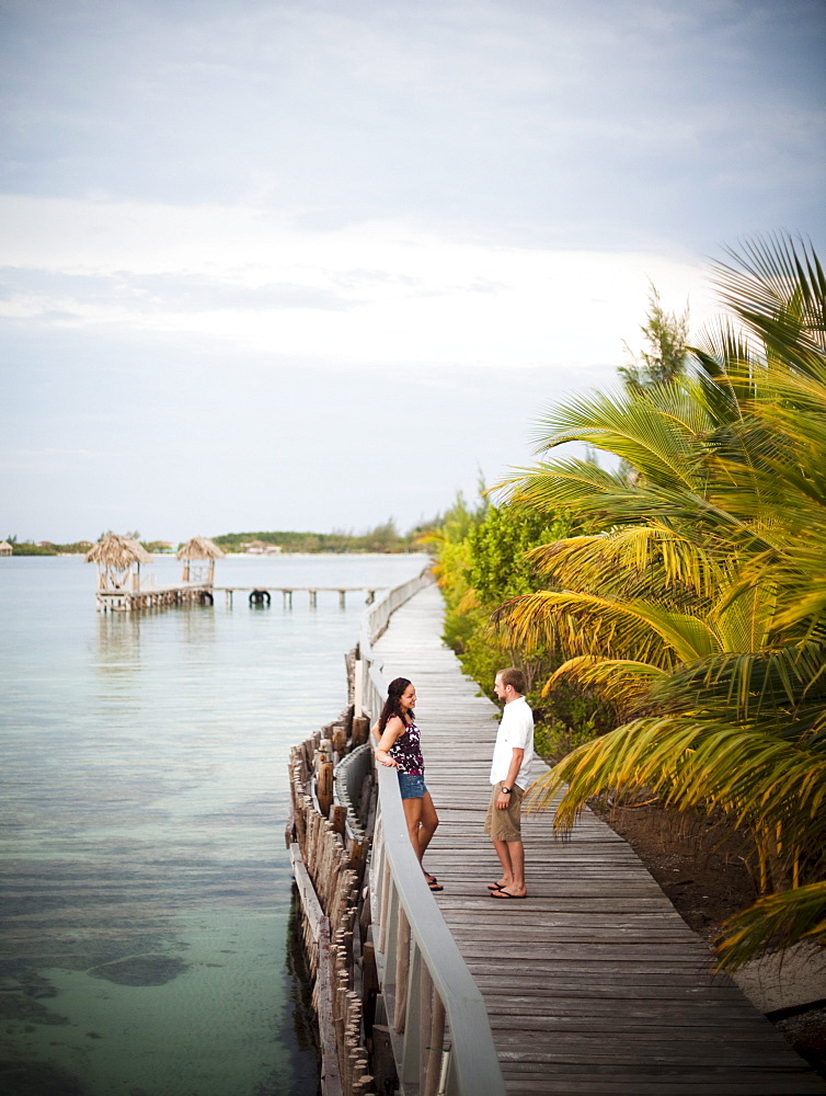 A couple enjoy the boardwalk at a small caye in Belize.