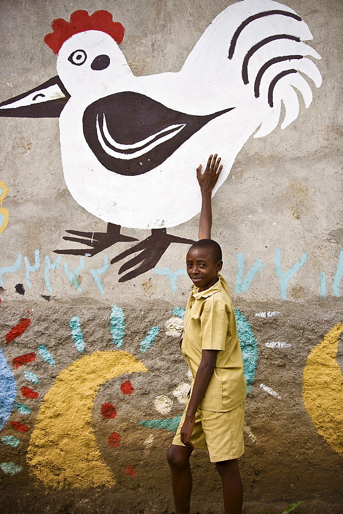 Rwandan boy shows off his painted home.