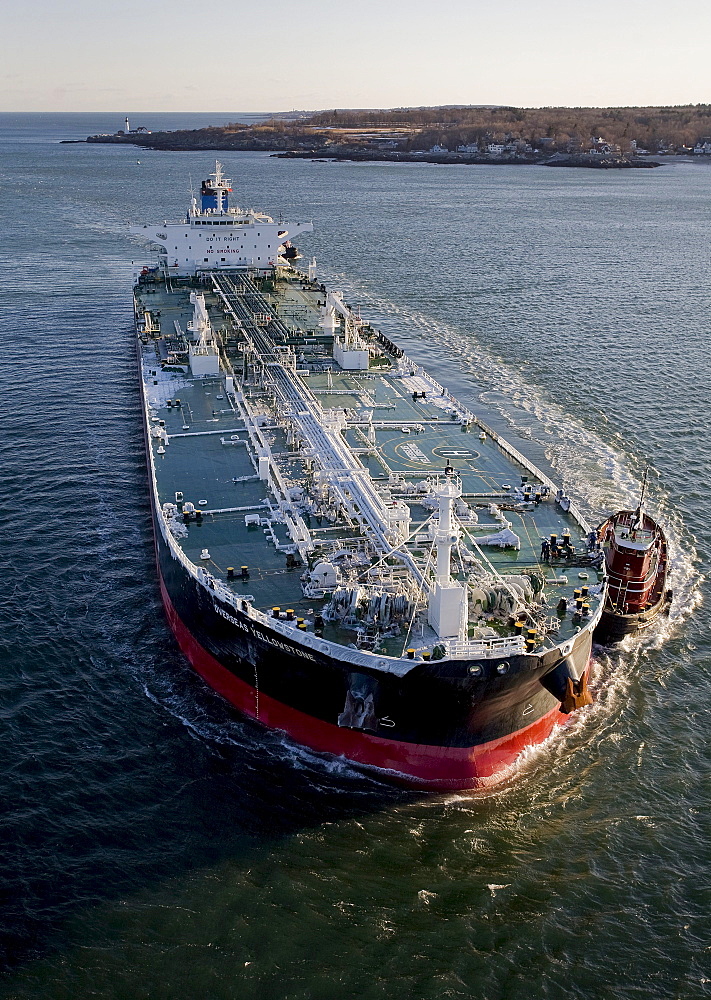 Oil tanker being piloted by tug boats into Portland Harbor, Maine.