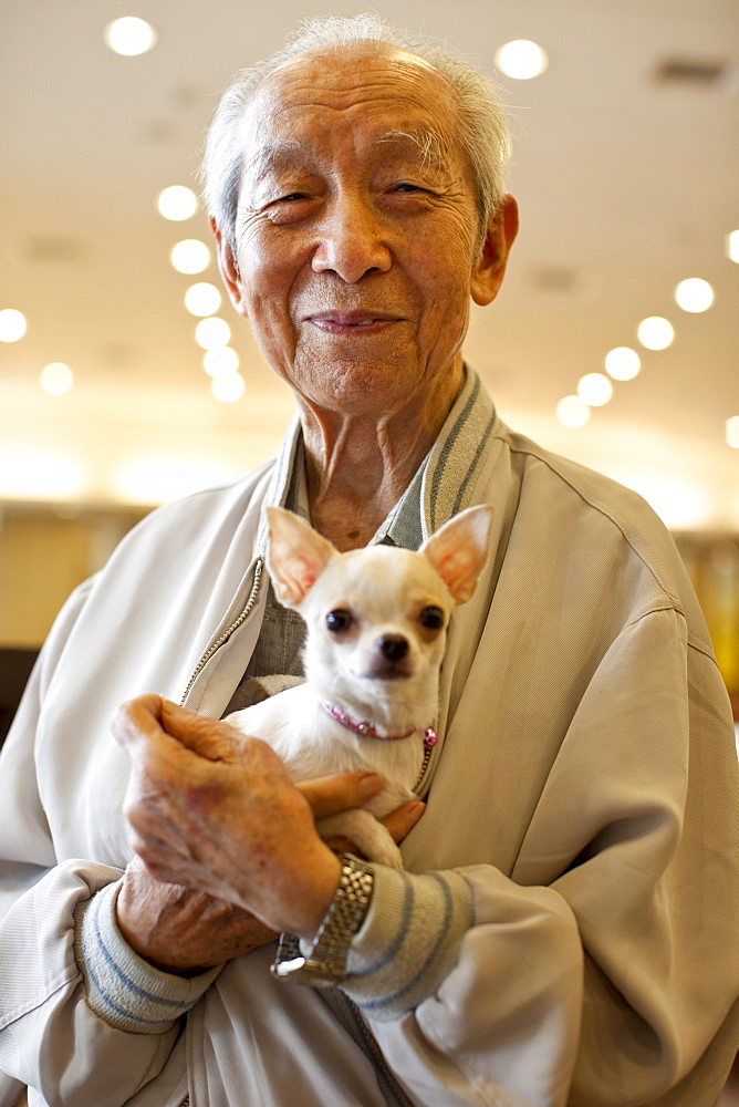 A Taiwanese man with his little dog, Puli Restaurant, Taiwan, October 21, 2010.