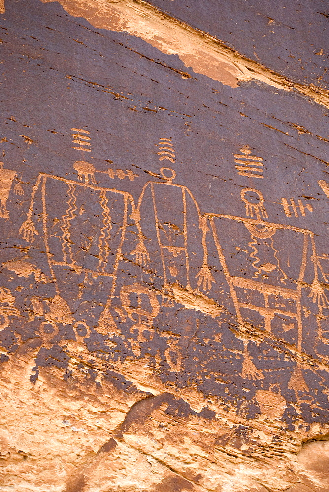 These Butler Wash Petroglyphs along the San Juan river are excellent examples of Indian petroglyphs. The large, square-shouldered figures are believed to be Kachinas, or gods, who are given rank by the stripes over their heads and may be seen to be giving speeches by the sound waves marked beside their heads.