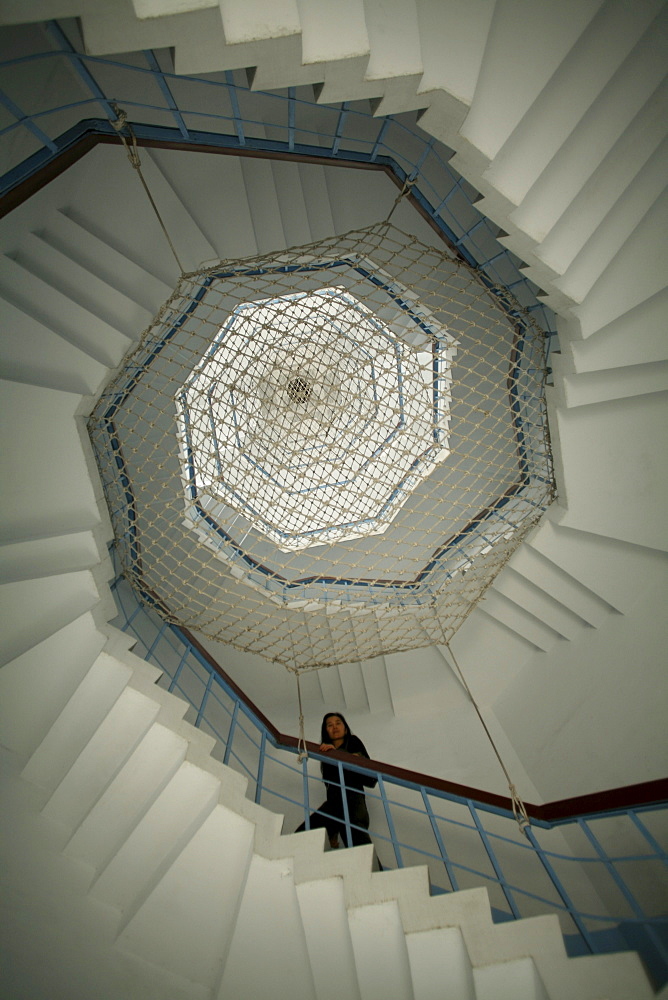 A woman ascends the stairs of the seven story Cien Pagoda.  Sun Moon Lake, Taiwan. 2007.