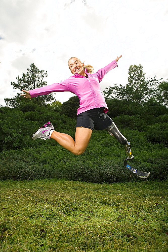 Sarah Reinertsen, the first female amputee to complete the Ironman Triathlon World Championship, jumps in the air for a portrait in Carlsbad, California.