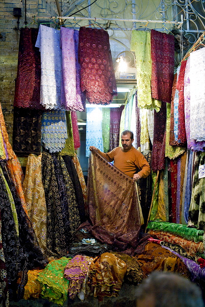 Shiraz, Iran - February, 2008: Silk salesman inside the colorful bazaar in Shiraz, Iran.