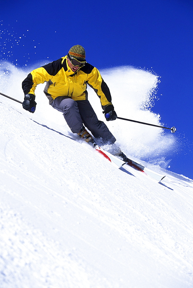 Man downhill skiing in Utah on a sunny day.