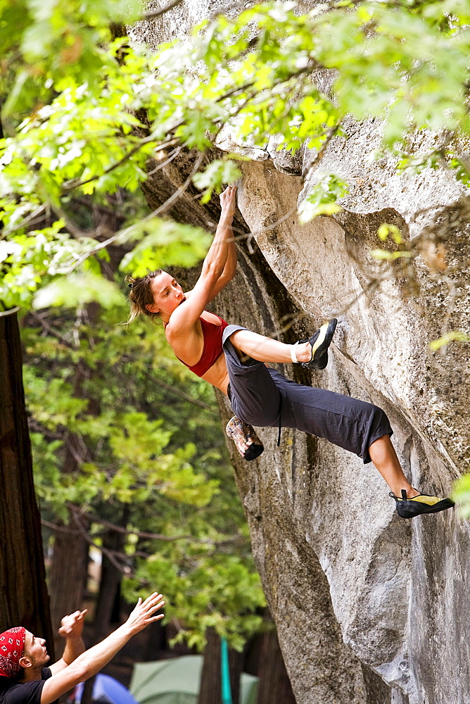 A female rock climber bouldering in Yosemite National Park.