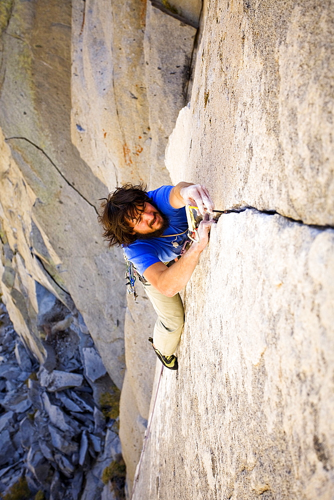 A male rock climber climbs a 5.10c crack in Jack's Canyon outside of Bishop, California.