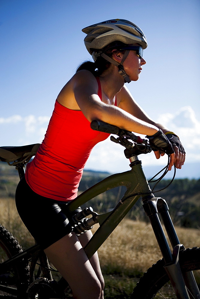 A female mountain biker stops to enjoy the view while riding the trails of Mt. Sentinel, Missoula, Montana.