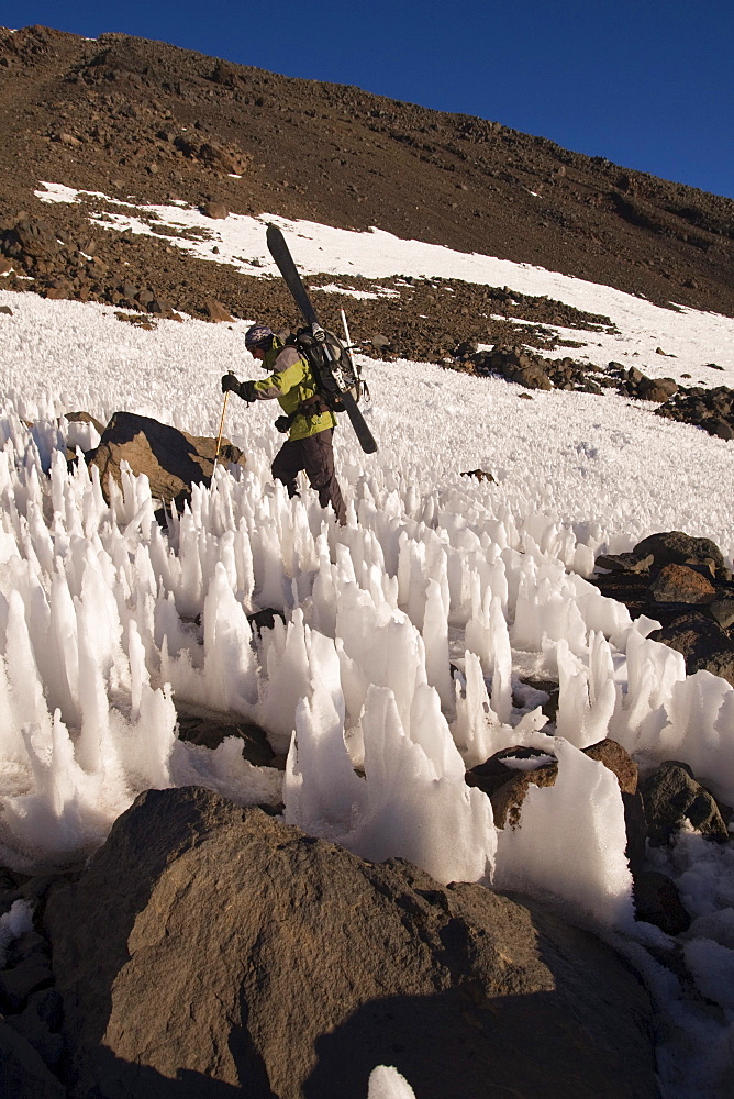 A man ski mountaineering through penitentes on Volcan San Jose in the Andes mountains of Chile