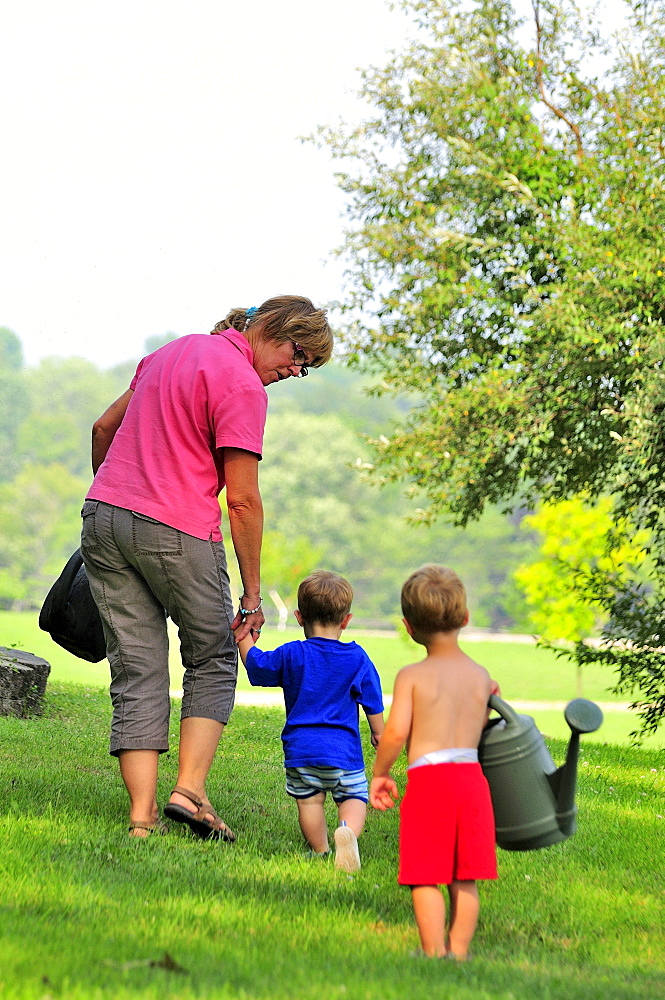 Grandmother and grandchildren with watering cans