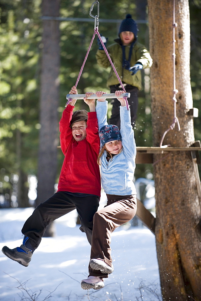 Three friends zipline over the snow in Lake Tahoe, California.