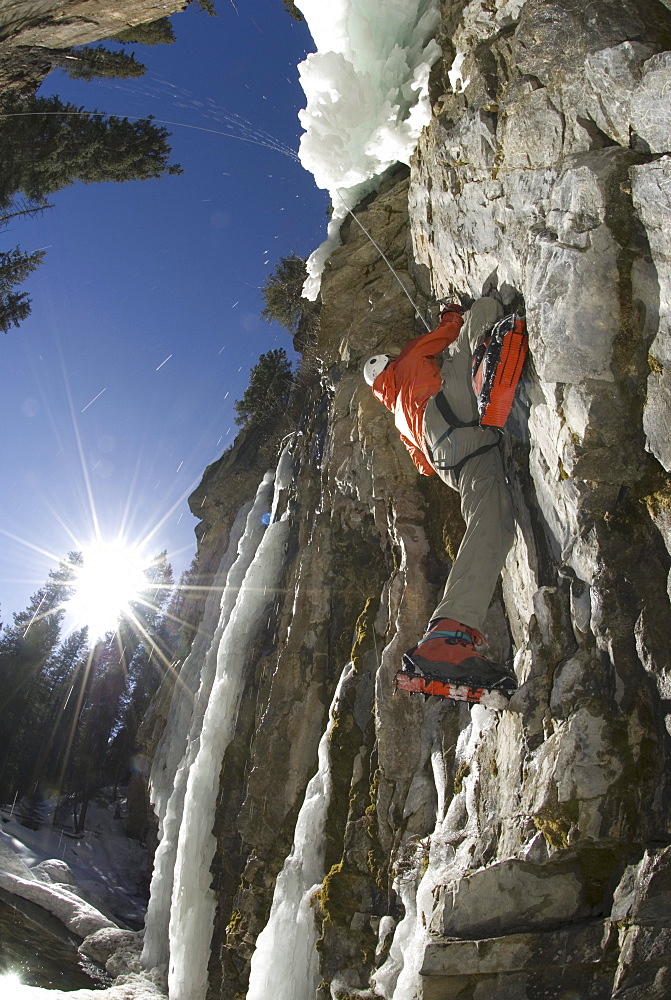 Man climbs up a mixed ice climb.