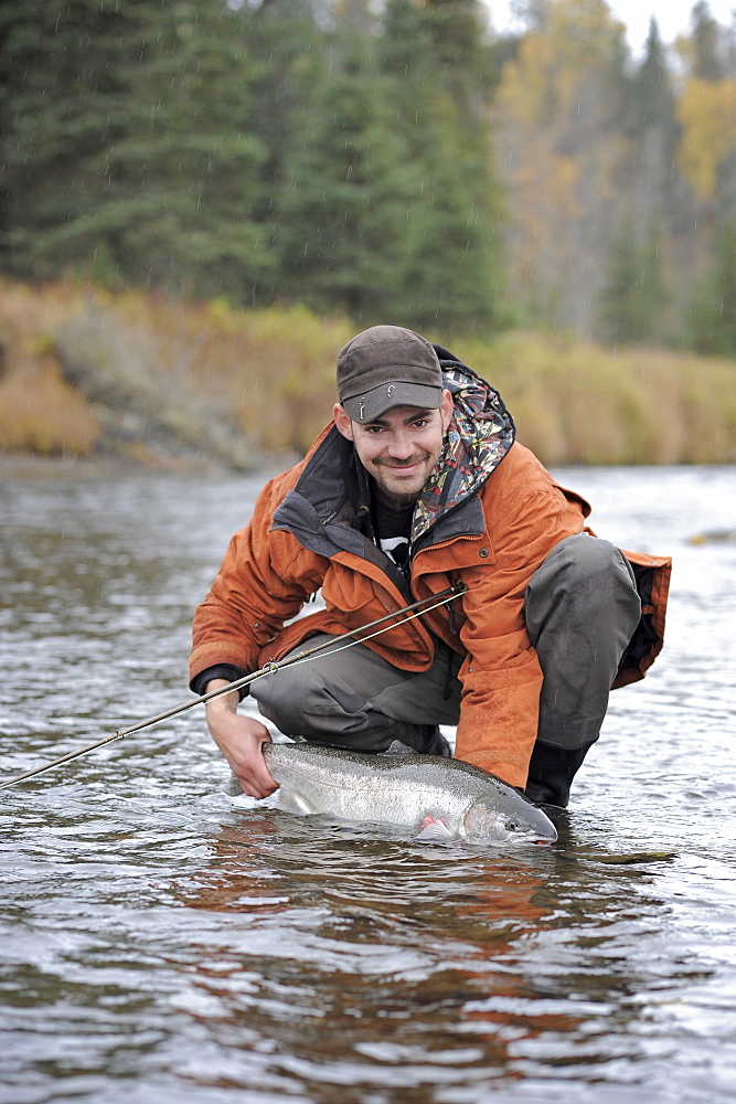 Fisherman with wild steelhead fished on Deep Creek on the Western Kenai Peninsula, Alaska September 2009.  Flowing into Cook Inlet north of Homer, the waters of Deep Creek and the Anchor River host late fall runs of wild steelhead.